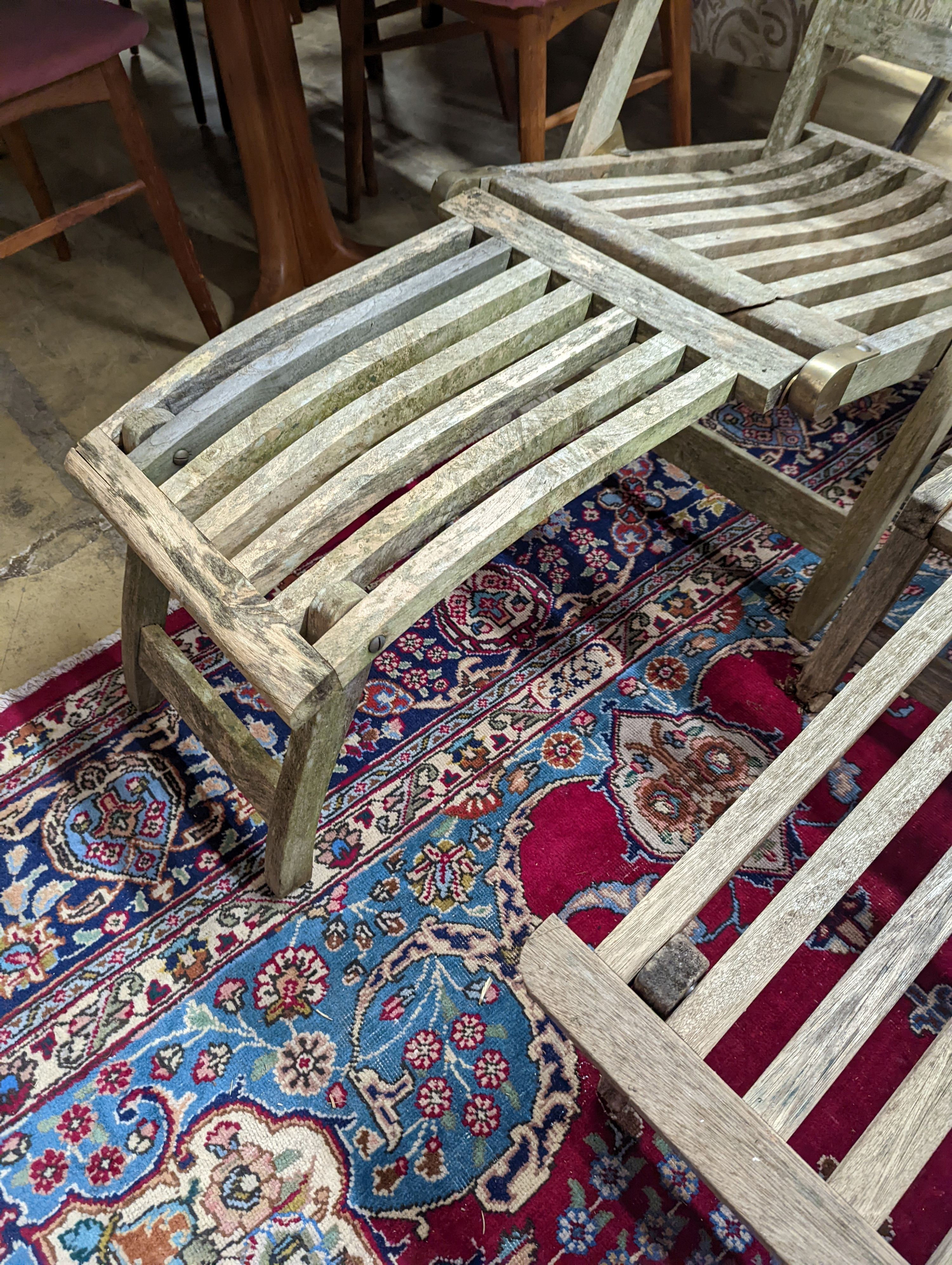 Two weathered teak garden steamer chairs. Heights for both chairs, 102cm and 88cm.